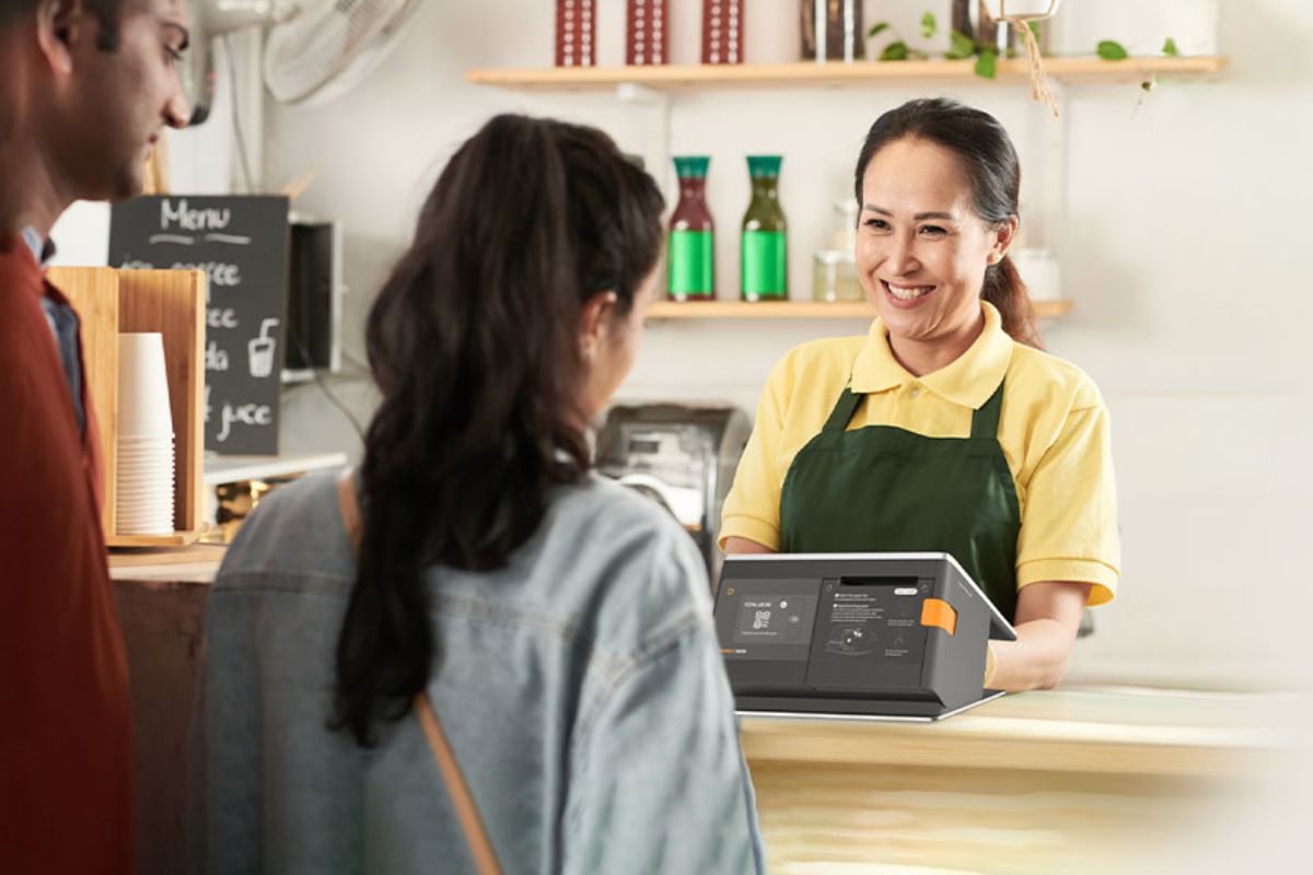 A F&B staff serving customers using a StoreHub POS