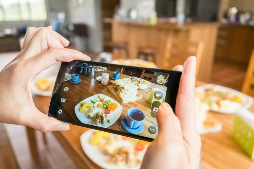 A person taking a photo of her food