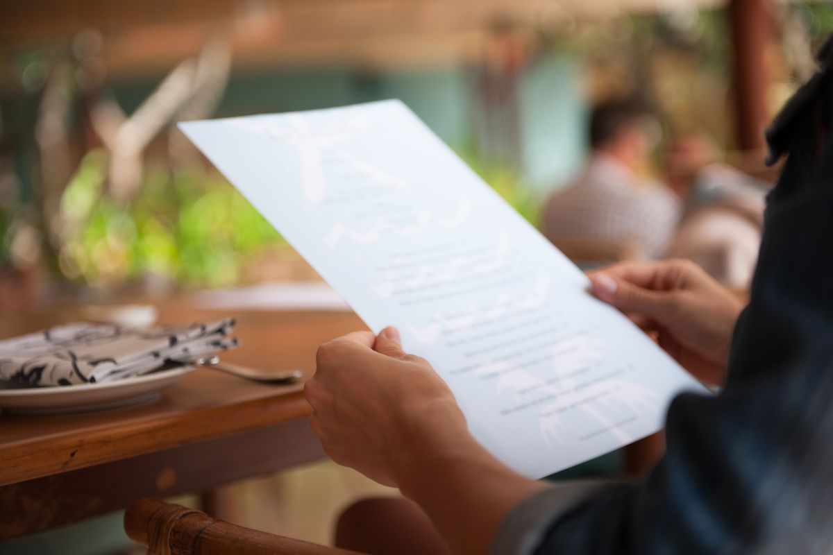 A Malaysian man reading the menu of a restaurant