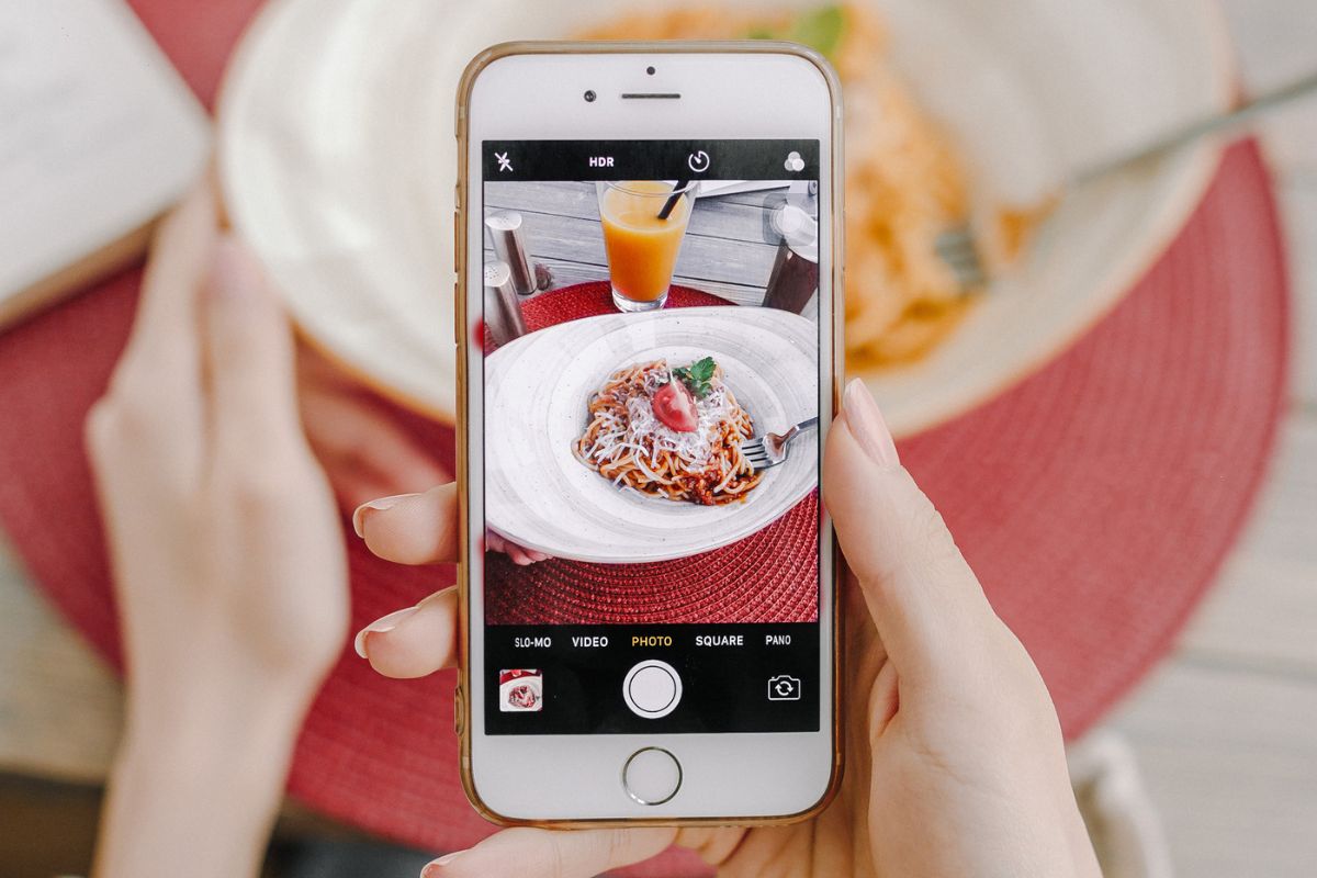A woman taking a photo of a plate of food