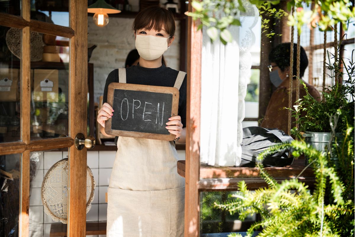 ing a chalkboard sign that says "Open"