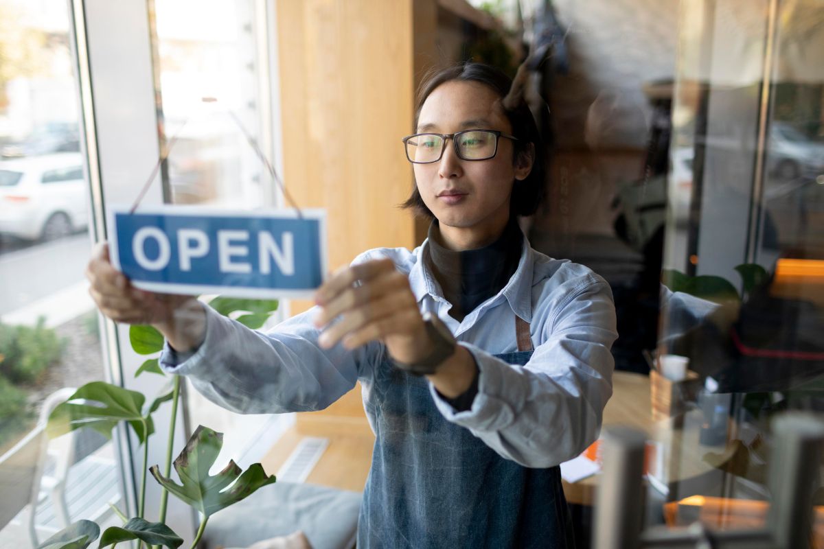 Waiter flipping the cafe's open sign