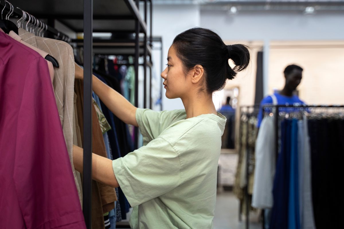 Customer browsing through a rack of clothes