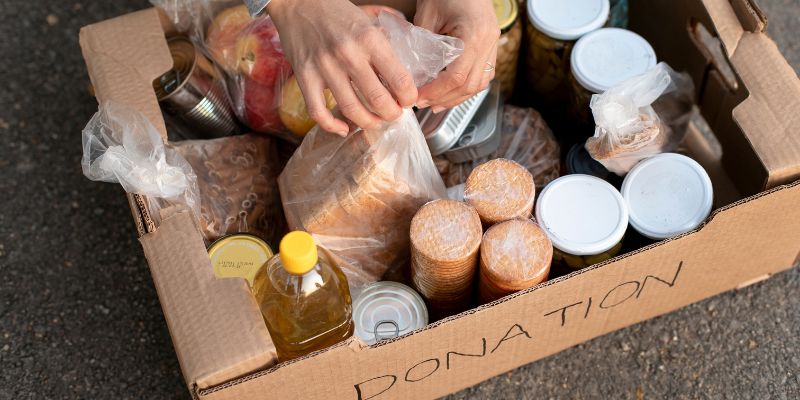 A person packing up left over food into a box