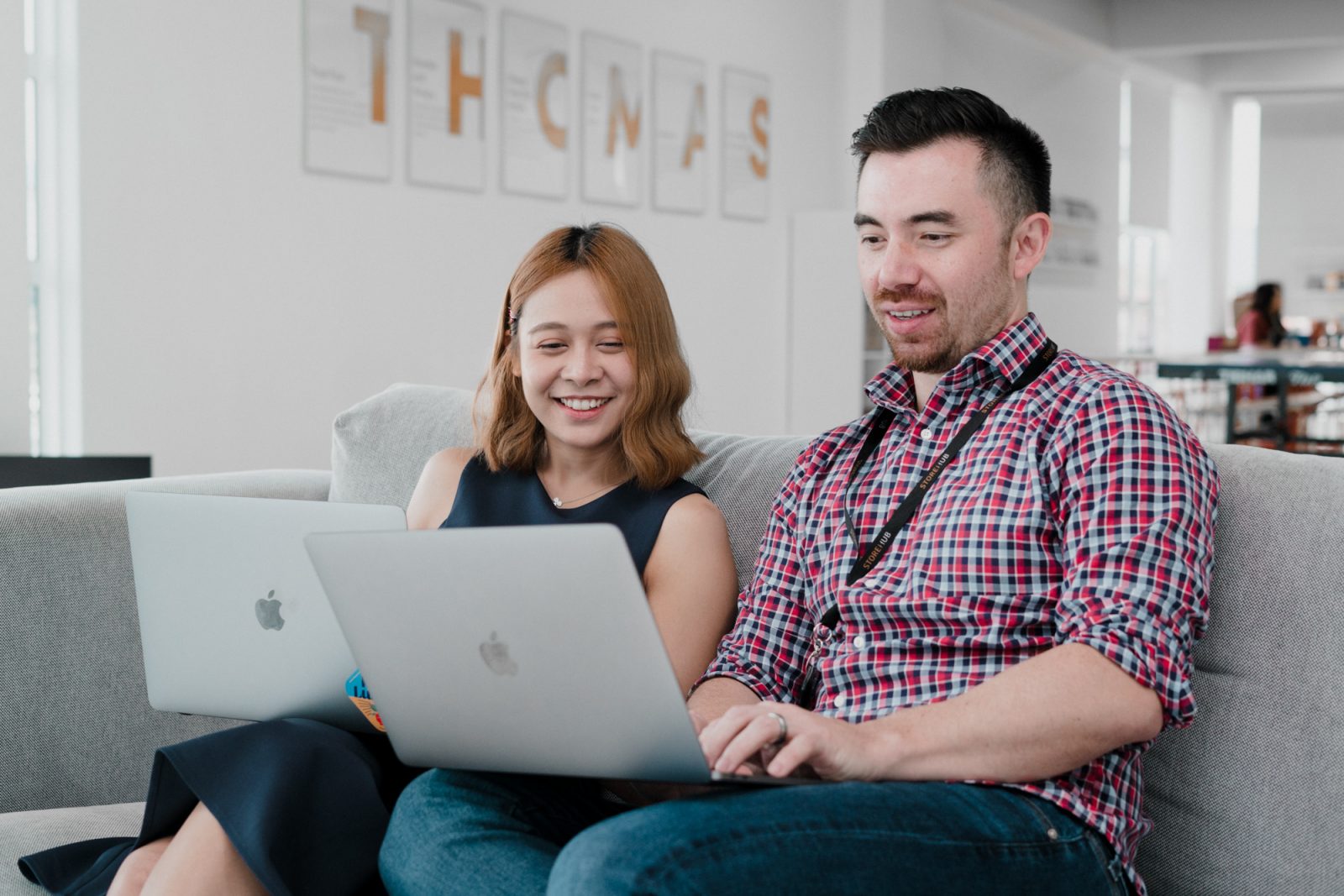 woman and man working on sofa with laptop