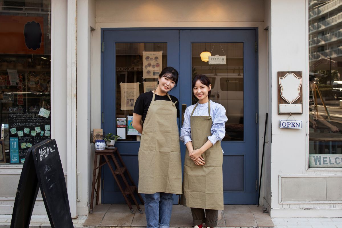 Two cafe owners standing in front of their cafe