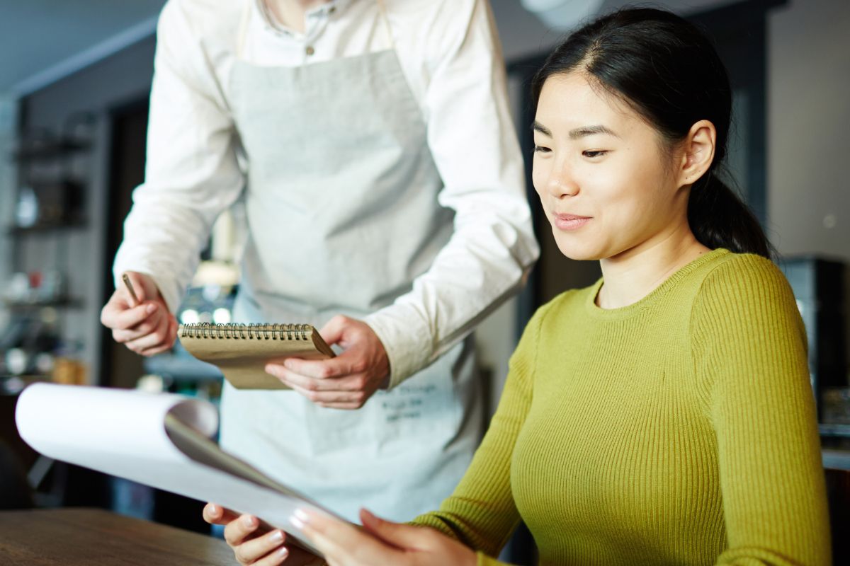 Waiter taking order of female customer