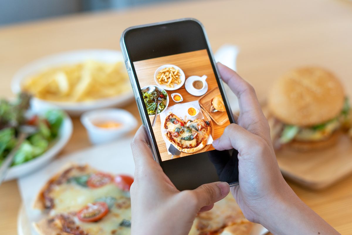 A person taking a photo of their food