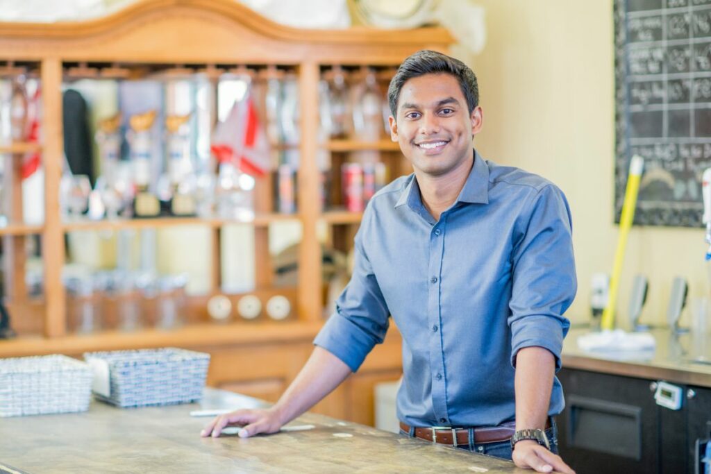 An Asian guy who is a young entrepreneur, smiling at the camera. 