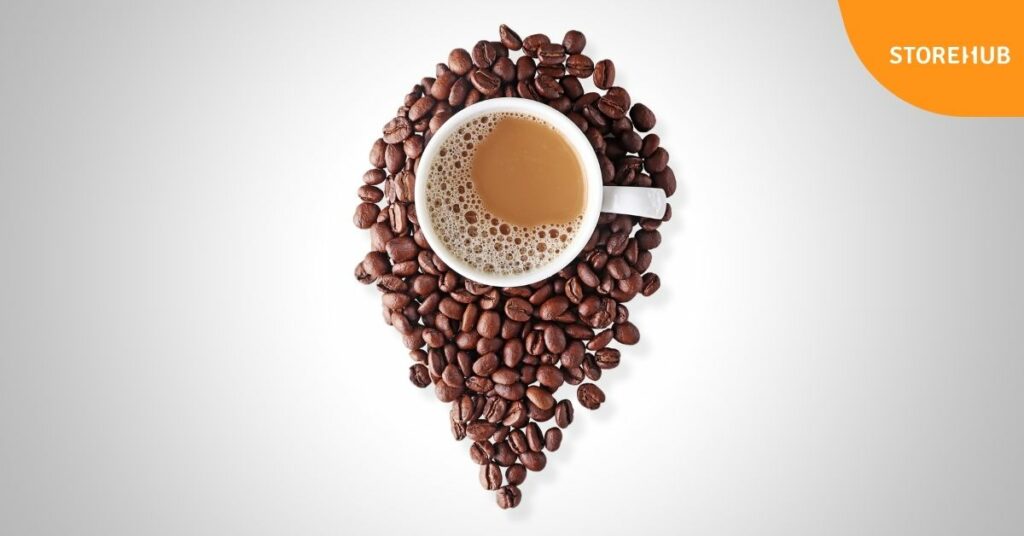 coffee on a cup with coffee beans surrounding it.