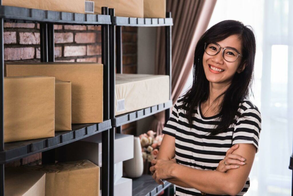 A business owner posing with boxes of her product