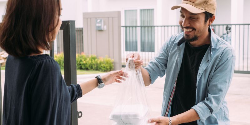 A Malaysian delivers food to a customer