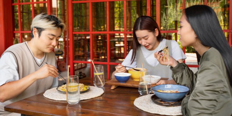 Three friends enjoying a meal in a restaurant