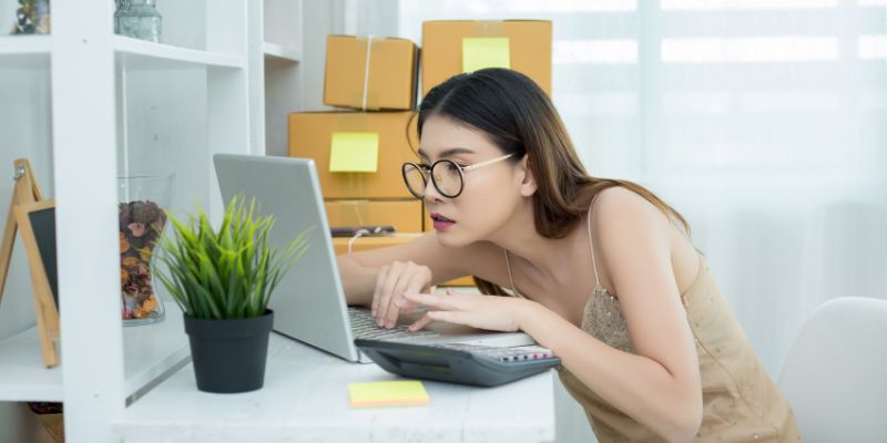 Business owner looking up close on her laptop