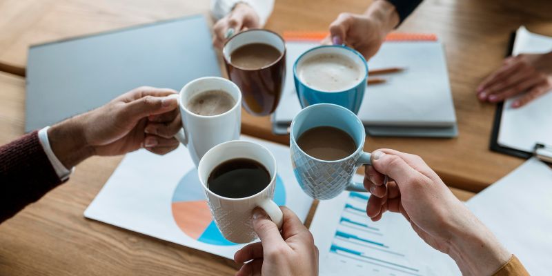 People holding coffee mugs filled with coffees together