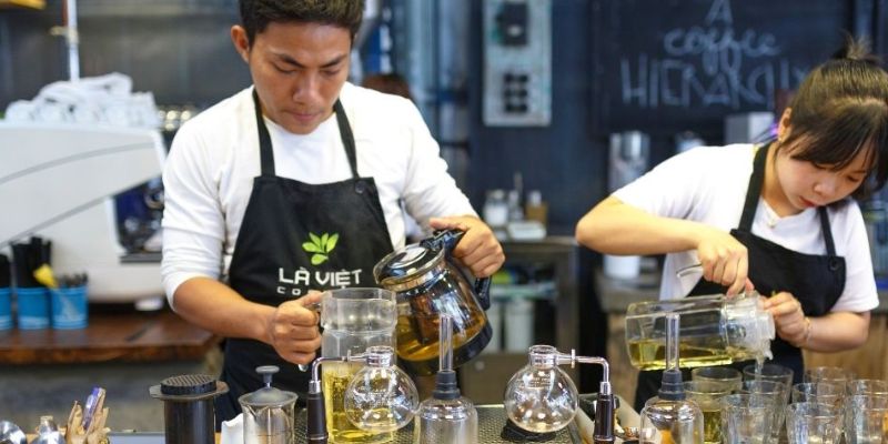 Two Barista's making coffee behind the counter