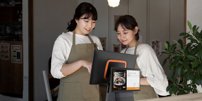 Two cashiers putting through orders through the POS system