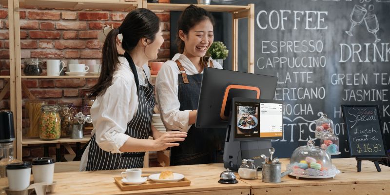 Two cashiers using a touch screen Point-Of-Sales system to key-in customers order