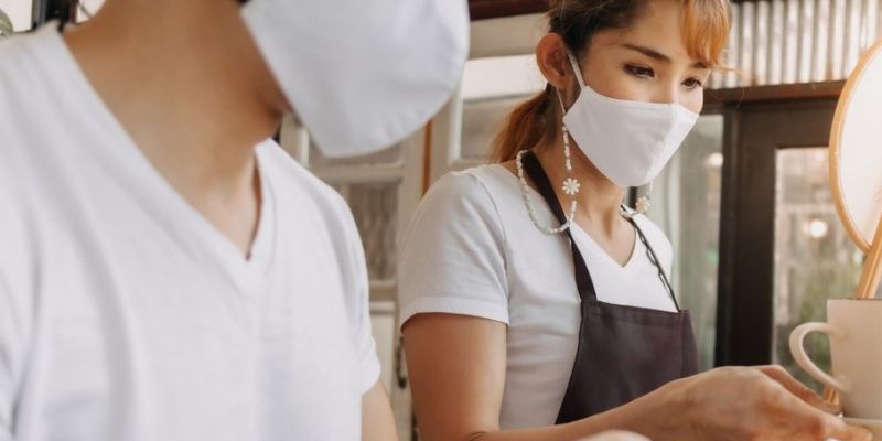 Barista wearing face masks while preparing coffee orders