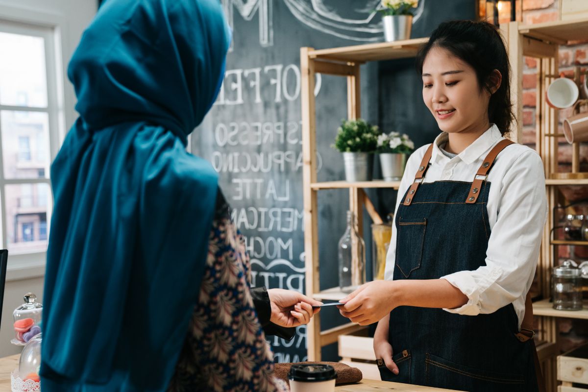 A Malaysian customer giving her loyalty card to the restaurant staff