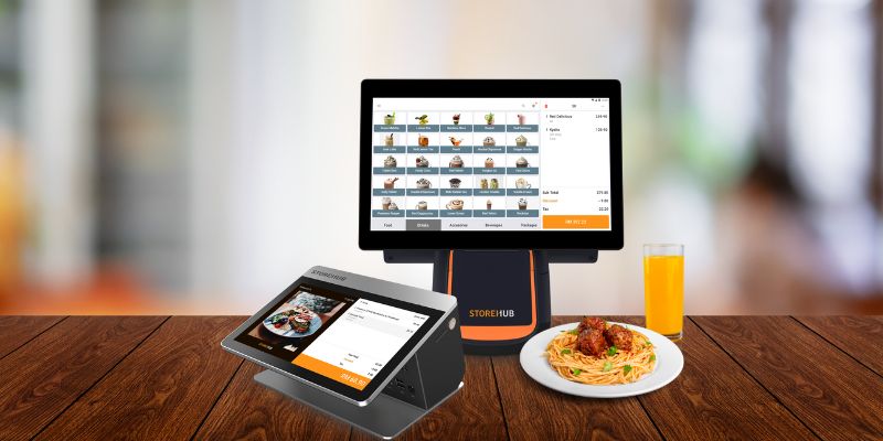 StoreHub POS on a countertop with pasta and juice in a cafe.