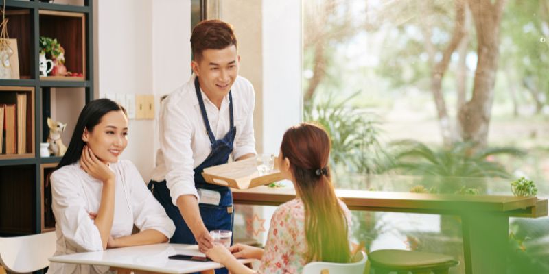 A Malaysian staff serving customers at a restaurant