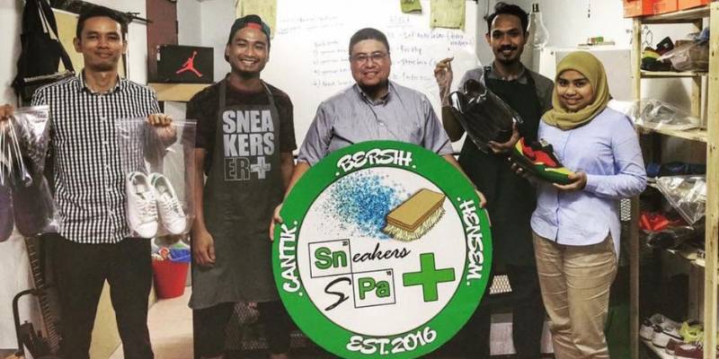 Pemilik Sneakers Spa, Azrul dan Adi sedang bergambar dengan pelanggan di stor mereka.