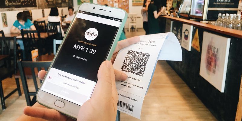 A customer scanning for Casback from a receipt with his phone at a cafe.