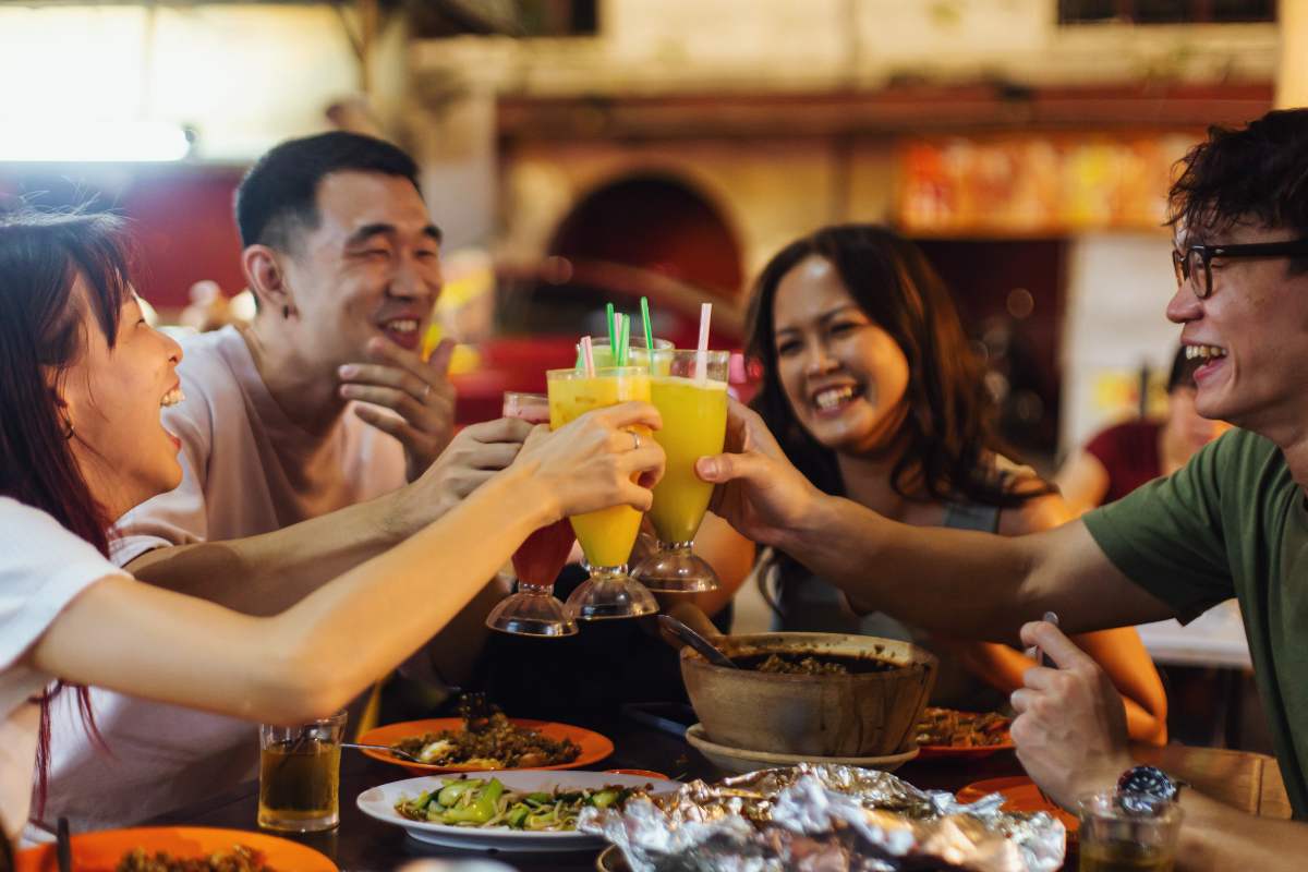 Empat orang pelanggan kelihatan gembira makan di salah sebuah restoran di Malaysia.