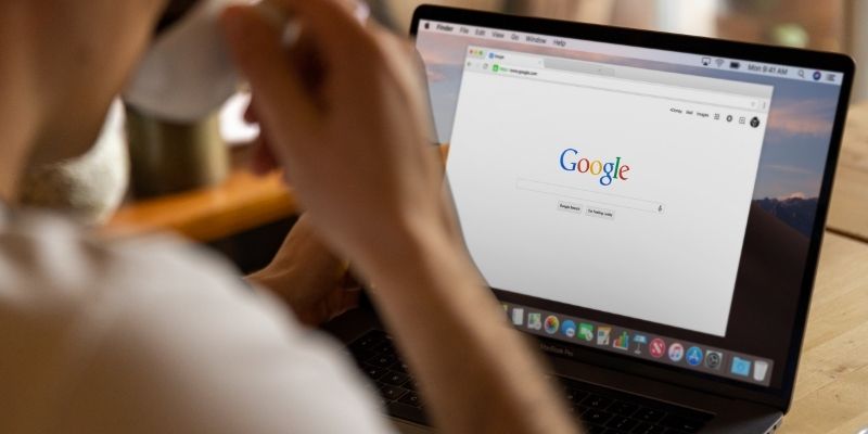 A Malaysian business owner in front of his laptop on a Google page, getting ready to learn about Google Ads