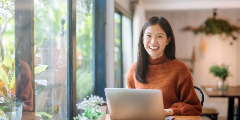 A Malaysian business owner on her laptop at a restaurant/cafe