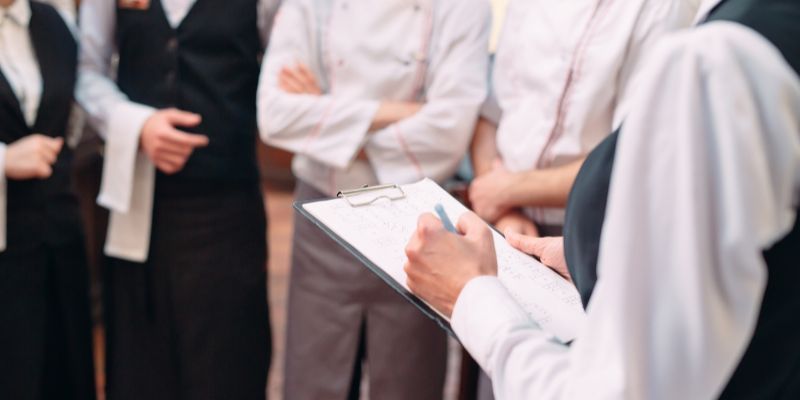 A restaurant manager leading a meeting with her staff