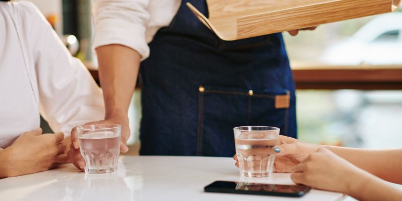 A waiter serving water to customers