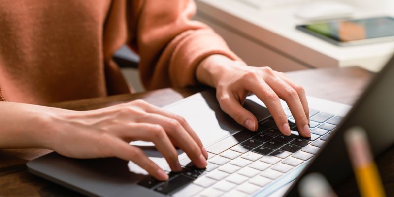 A Malaysian woman typing on a laptop
