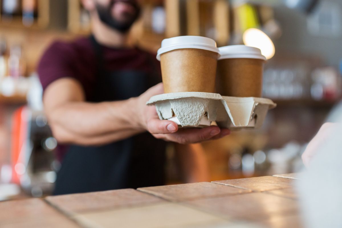 A Malaysian restaurant owner serving coffee to his customer