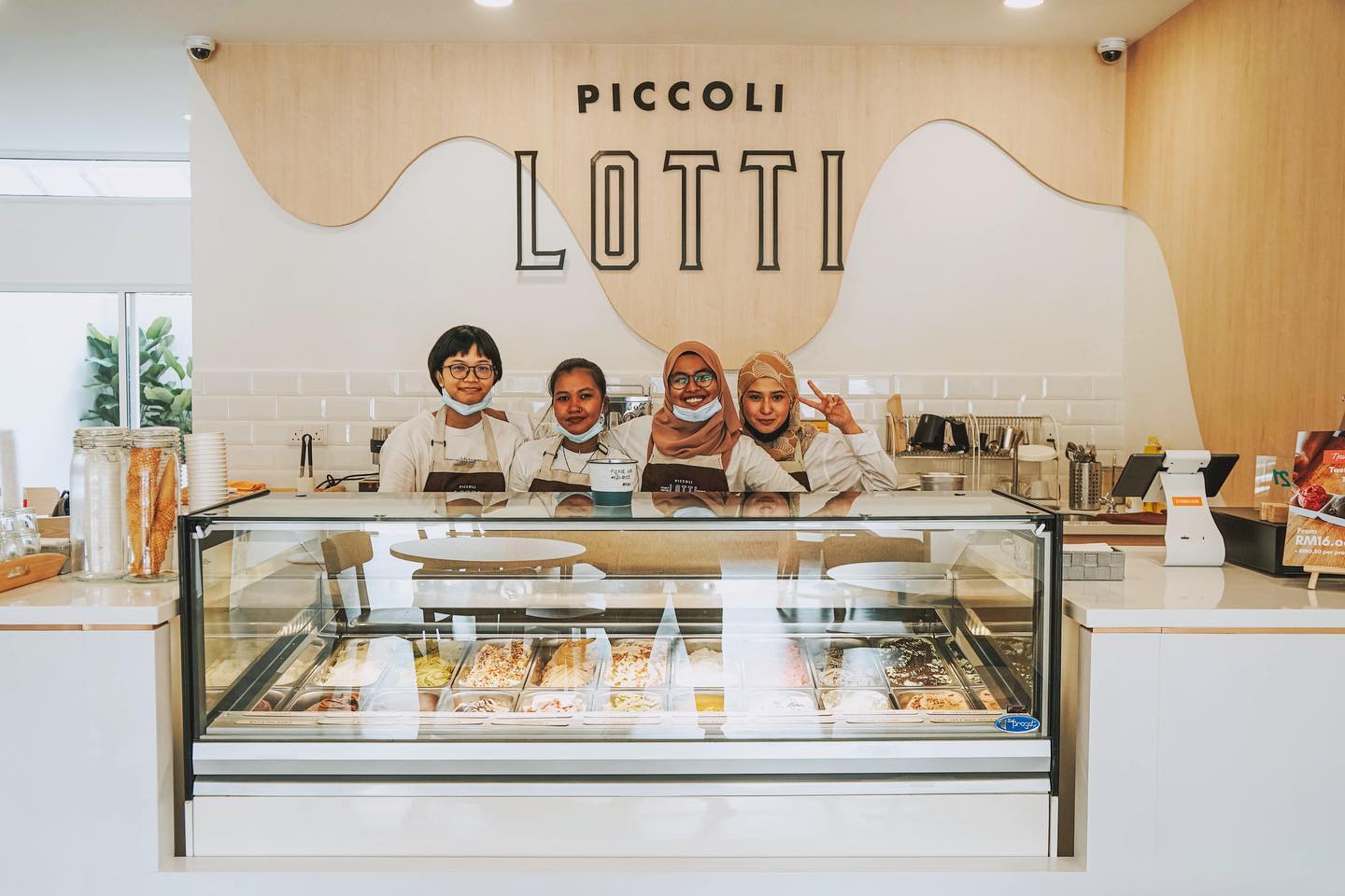 Staff smiling behind counter of gelato shop
