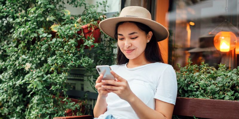 A Malaysian restaurant customer texting on her phone