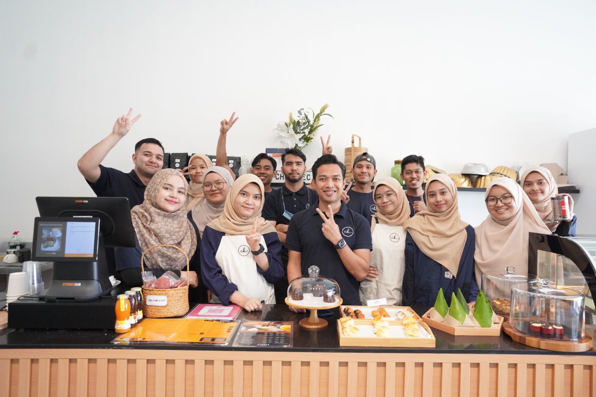 Peniaga bisnes F&B bersama sepasukan staf dibelakang kaunter POS StoreHub di dalam cafe viral Chef Kecik.