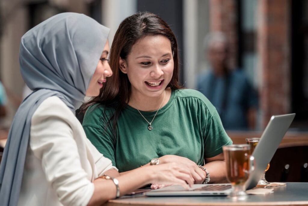 Malaysian small business owners using a laptop to learn about community banking
