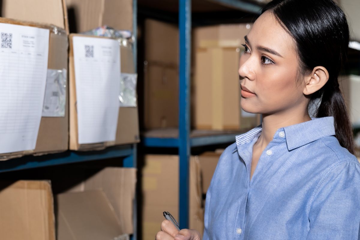Wanita Malaysia menyemak stok di gudang