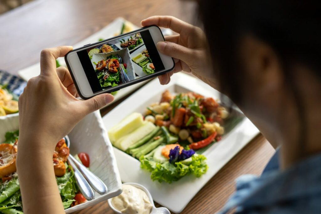 A woman taking a photo of her food for social media