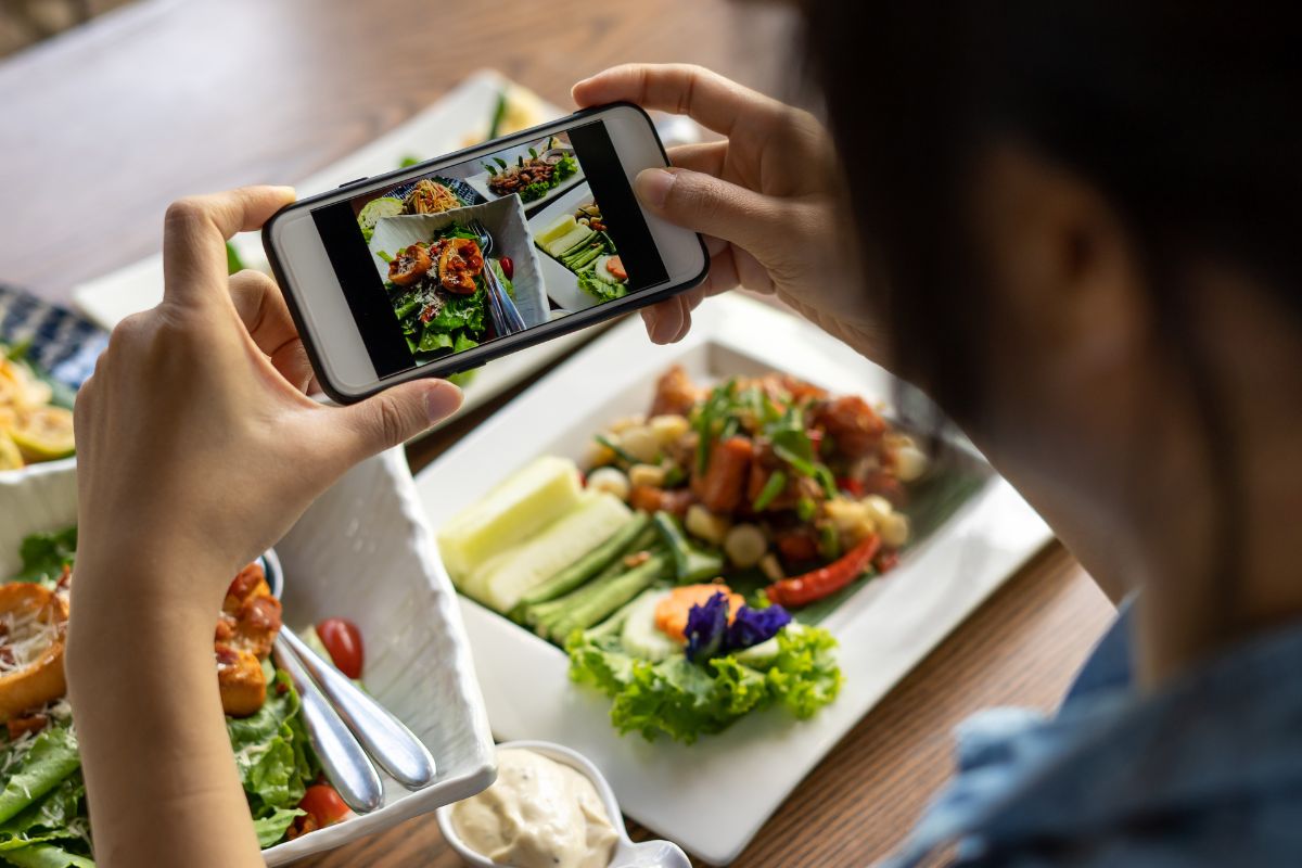 A woman taking a photo of her food for social media