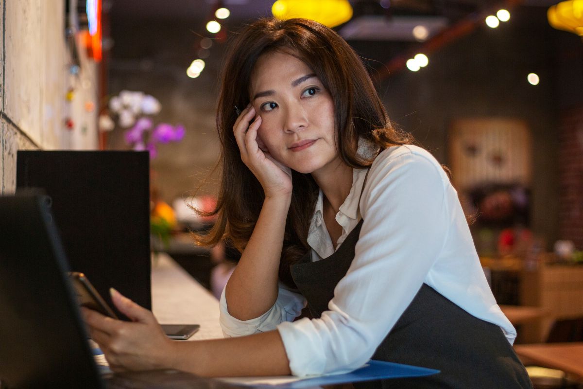 A Filipino F&B business owner in her restaurant, deep in thought