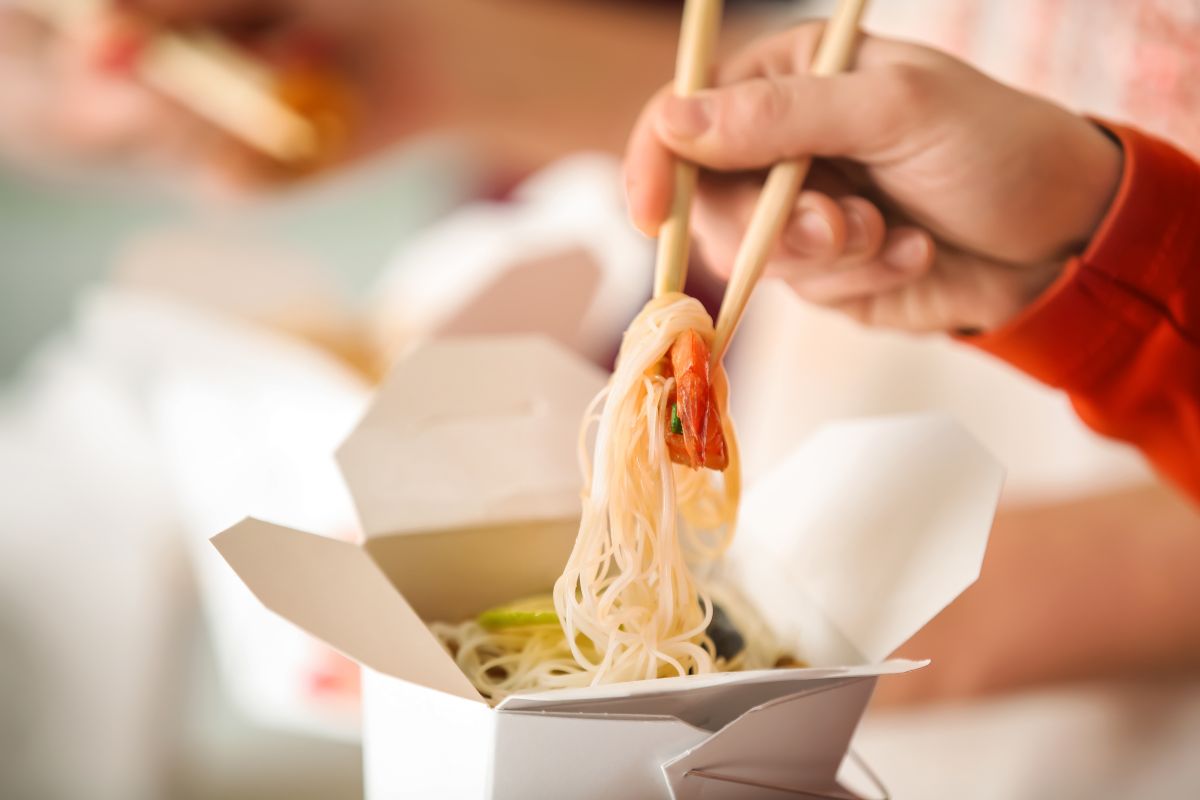 A person eating takeaway food at home