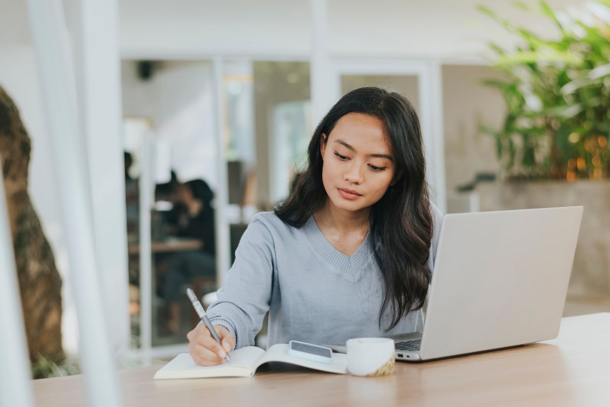A woman writing on a notebook
