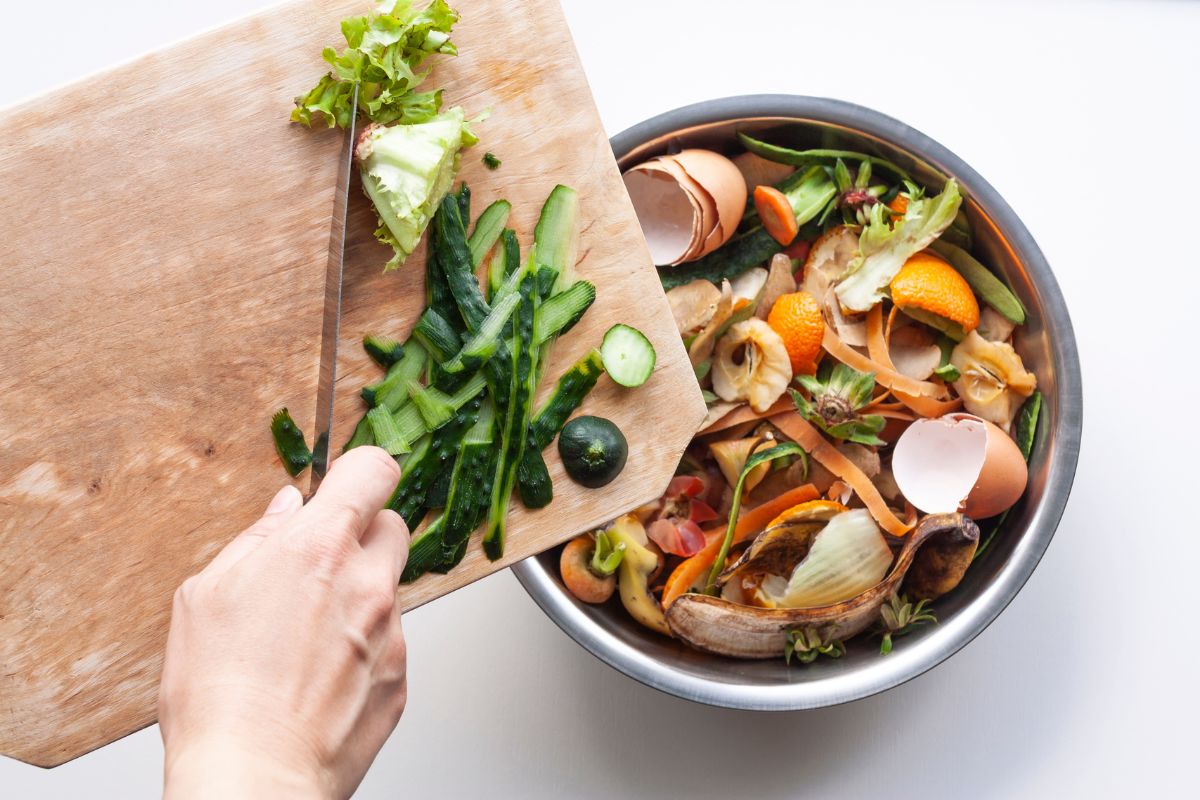 A Filipino woman dumping food waste into a bowl