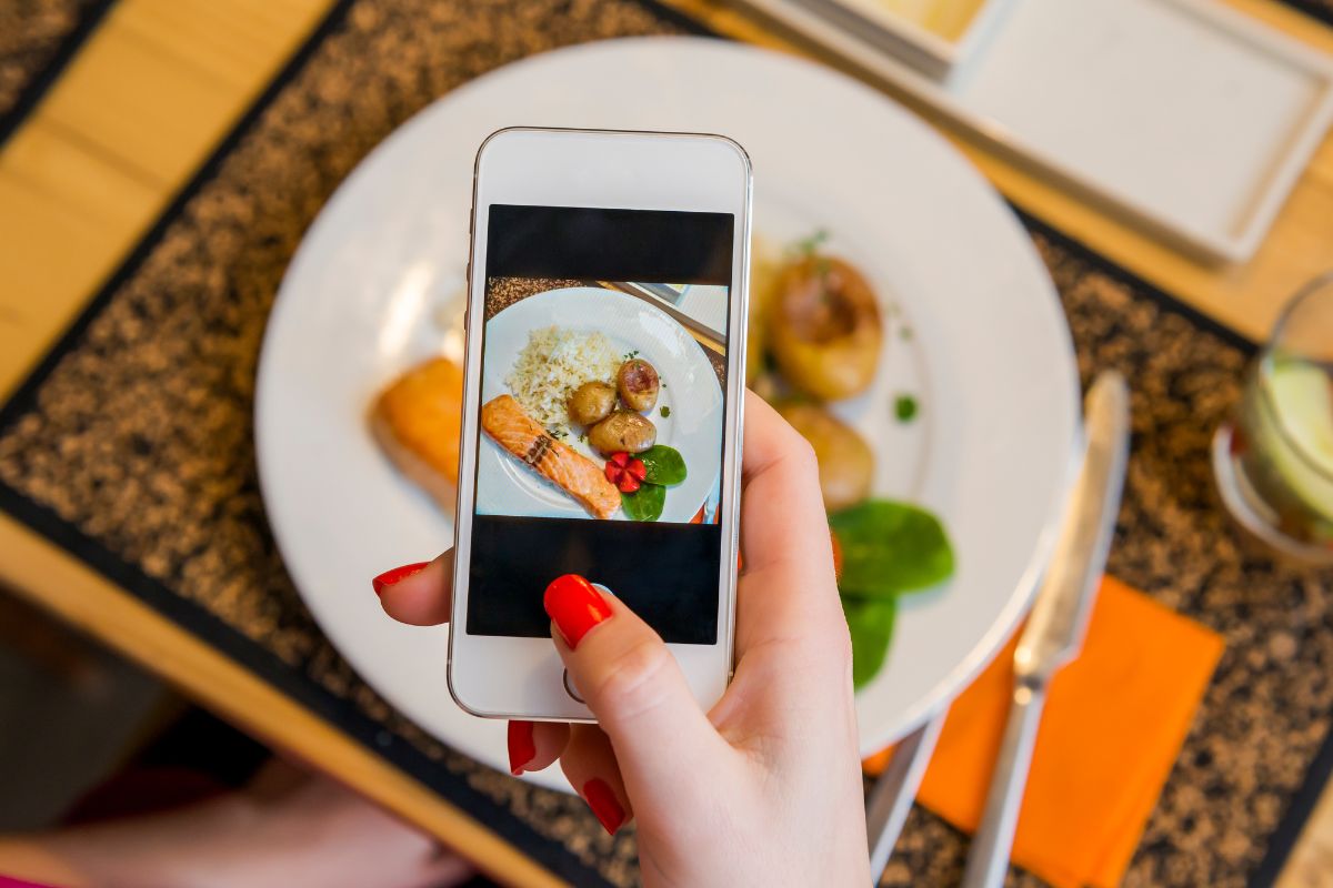 A person taking a photo of their food
