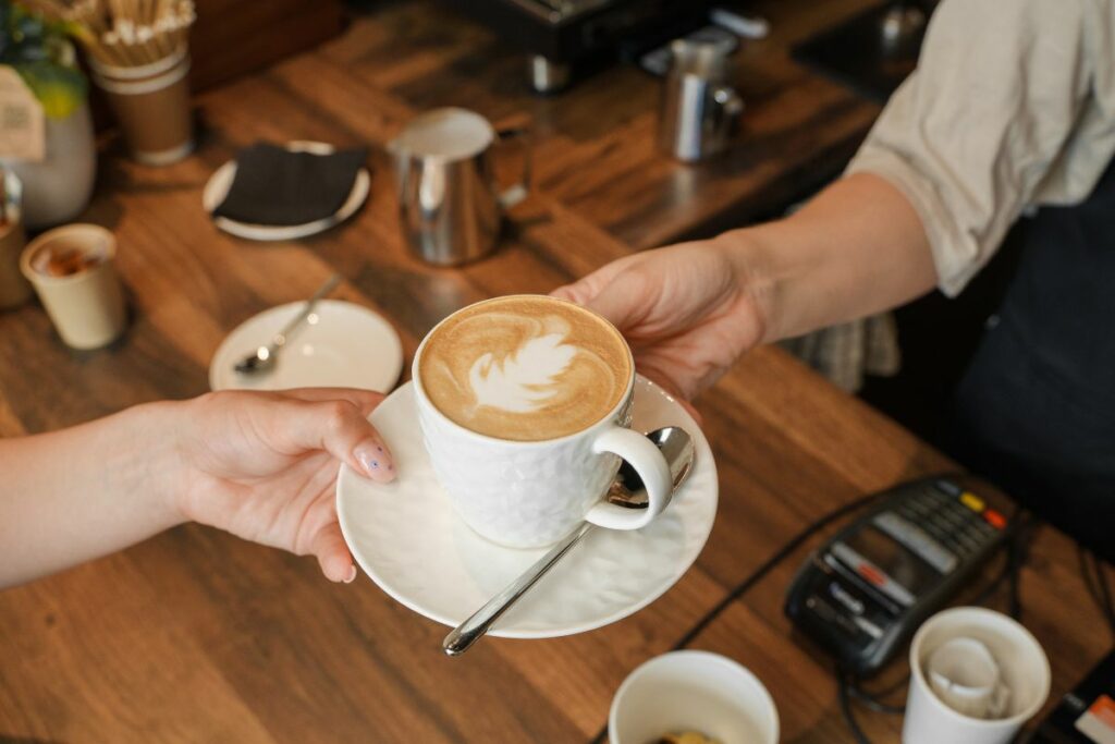 A F&B business owner serving coffee to a customer