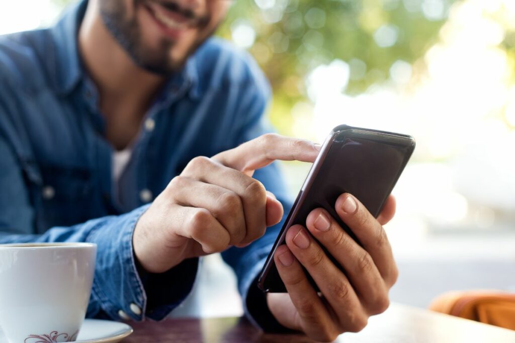 A man sending an SMS through his mobile phone