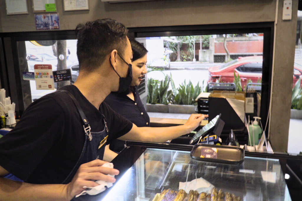 Business owners with a staff using StoreHub POS in a cafe